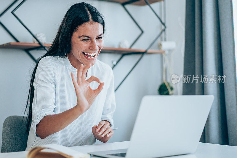 Portrait of a cheerful woman having video call at home.